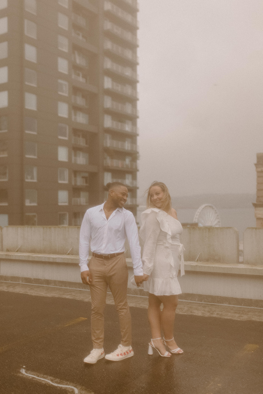 Couples photos in the rain for a rooftop engagement session
