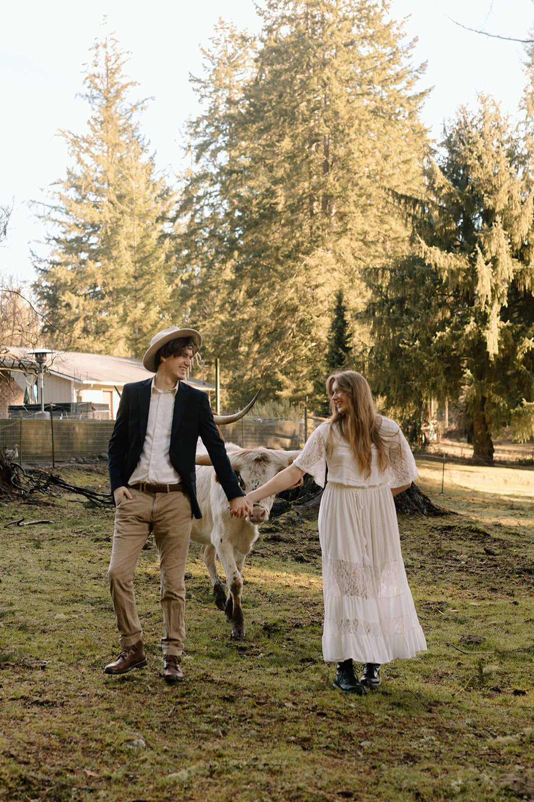Couple running through open field with cows for their PNW Engagement Photos