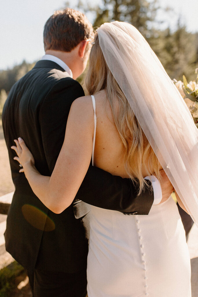 A bride and groom hugging after their wedding ceremony at gold creek pond in Washington after learning wedding planning tips