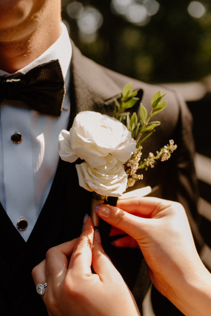 A floral boutonniere being pinned on the groom
questions to ask wedding vendors