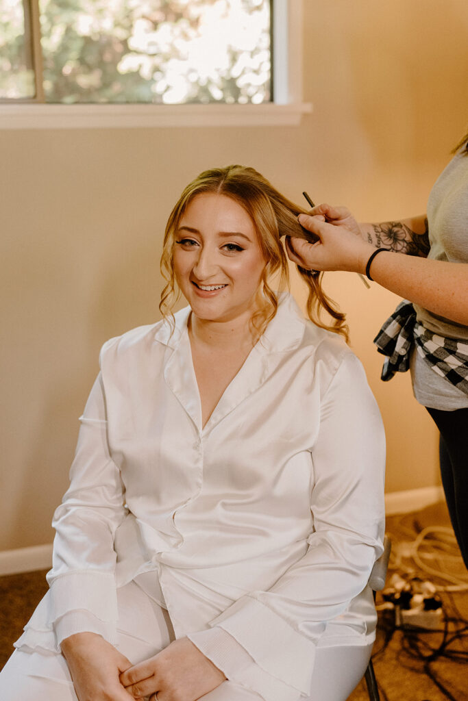 A bride sitting in a makeup chair getting her hair done
questions for wedding vendors
