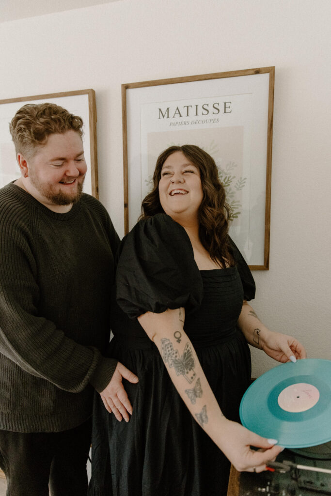 Couple putting on a blue record to announce their pregnancy. 