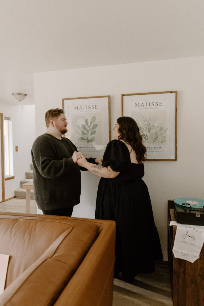 A couple dancing to their record player during their in home pregnancy announcement photoshoot.