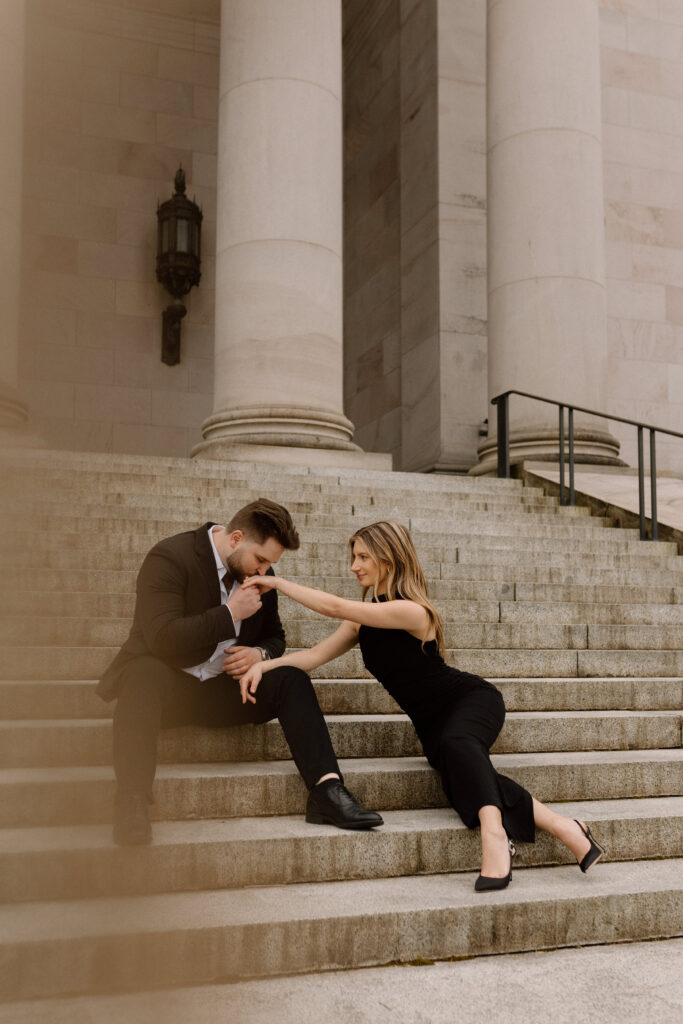 Couple sitting on the steps of the Washington State Capitol Building for their engagement photoshoot.
