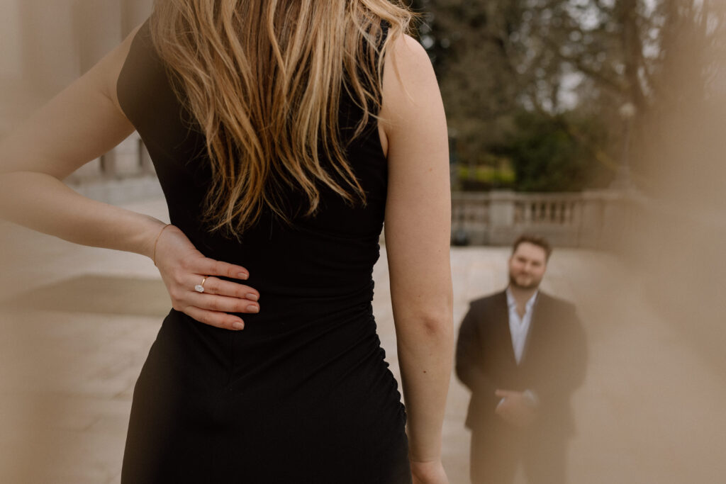 Man admiring his fiance during their engagement photoshoot. Main focus is on her engagement ring.