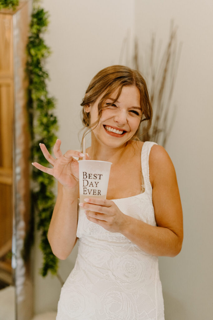 bride on wedding day holding best day ever cup