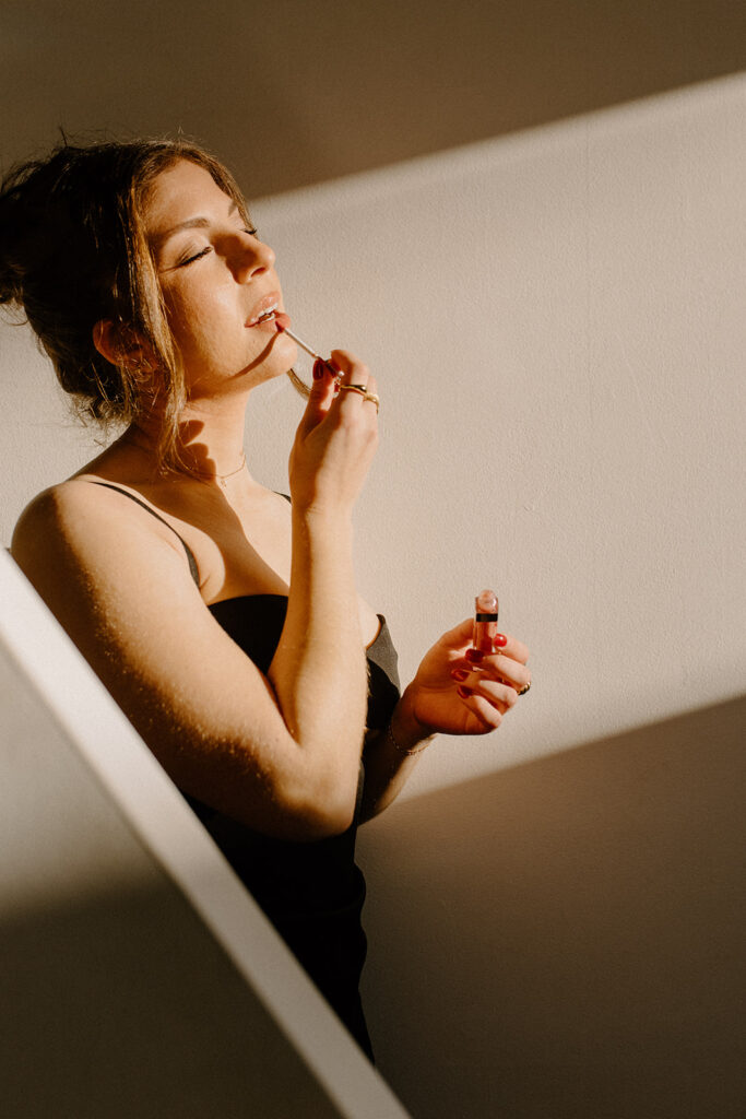 a woman sensually putting on lipstick.