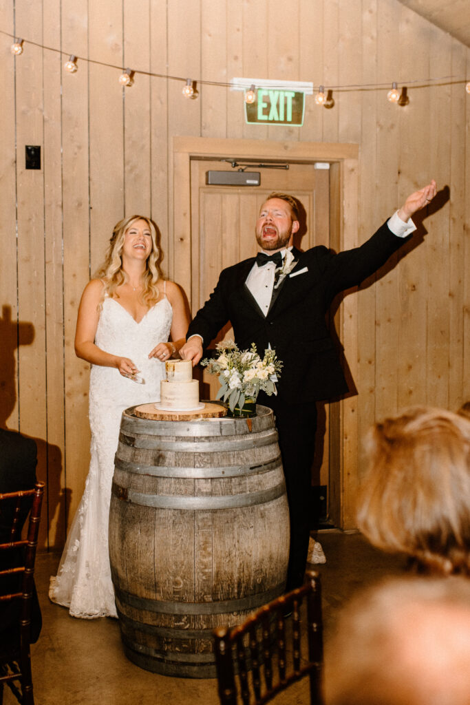 bride and groom cheering for cake cutting