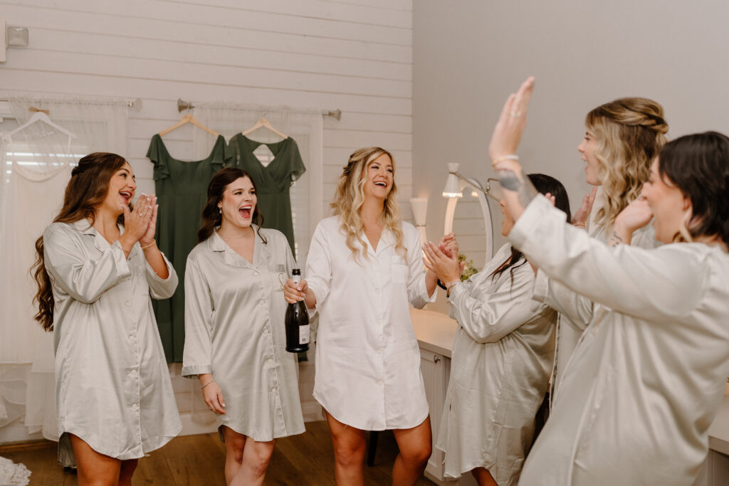 bride and bridesmaids popping champagne