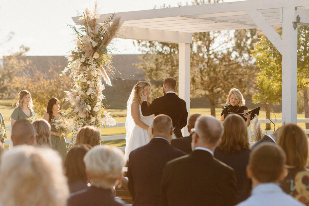 groom wiping the brides tear at the ceremony