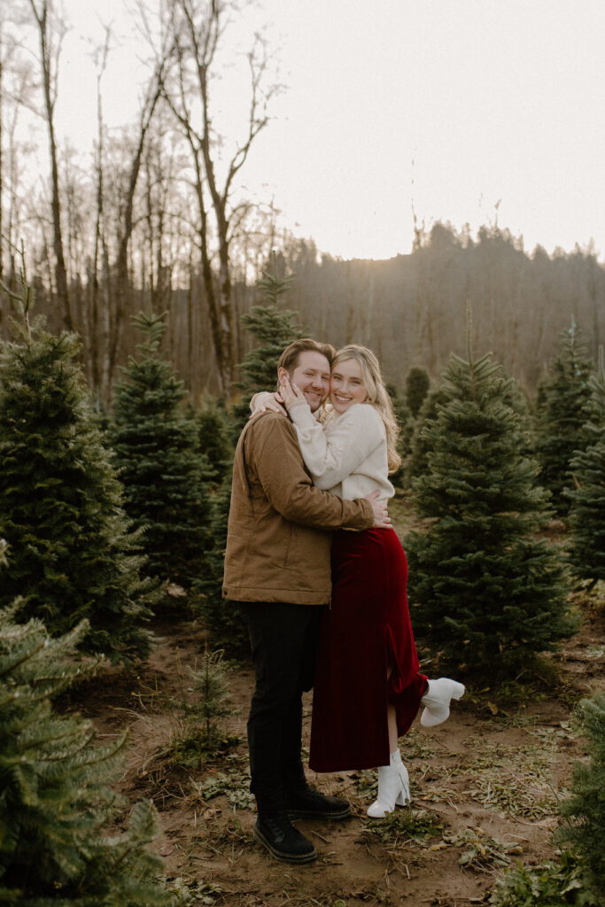 couples posing for holiday tree farm photoshoot