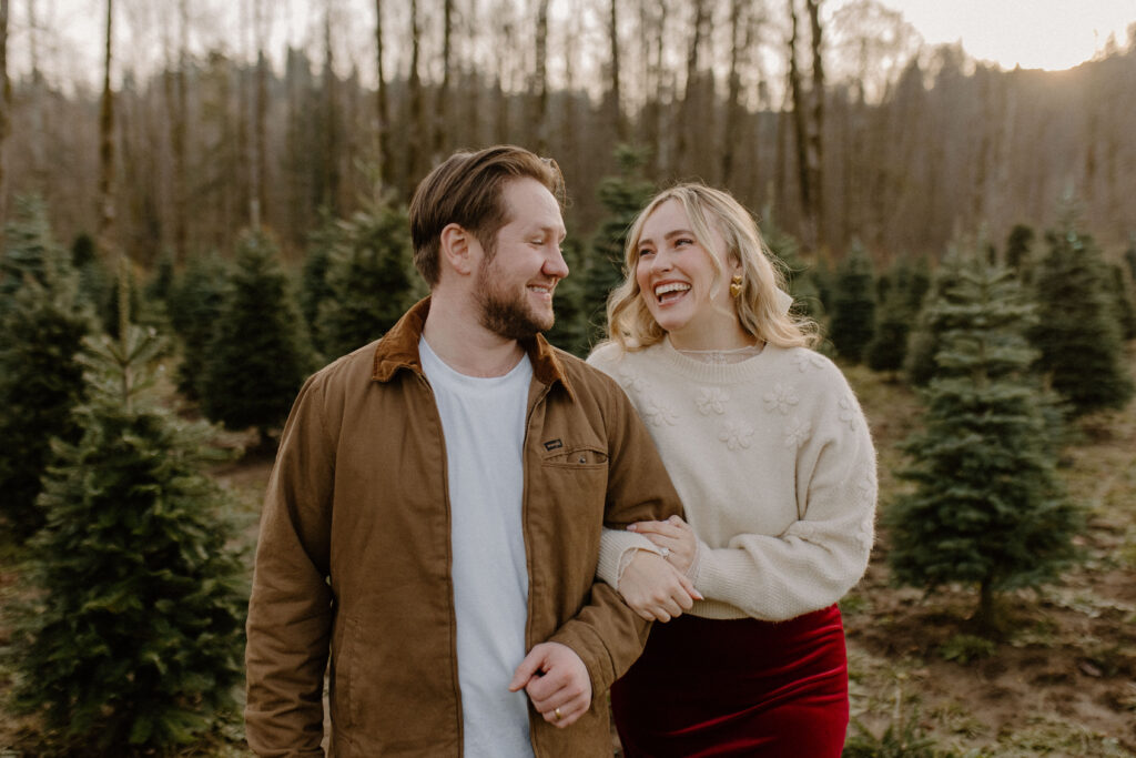 couples posing for holiday tree farm photoshoot