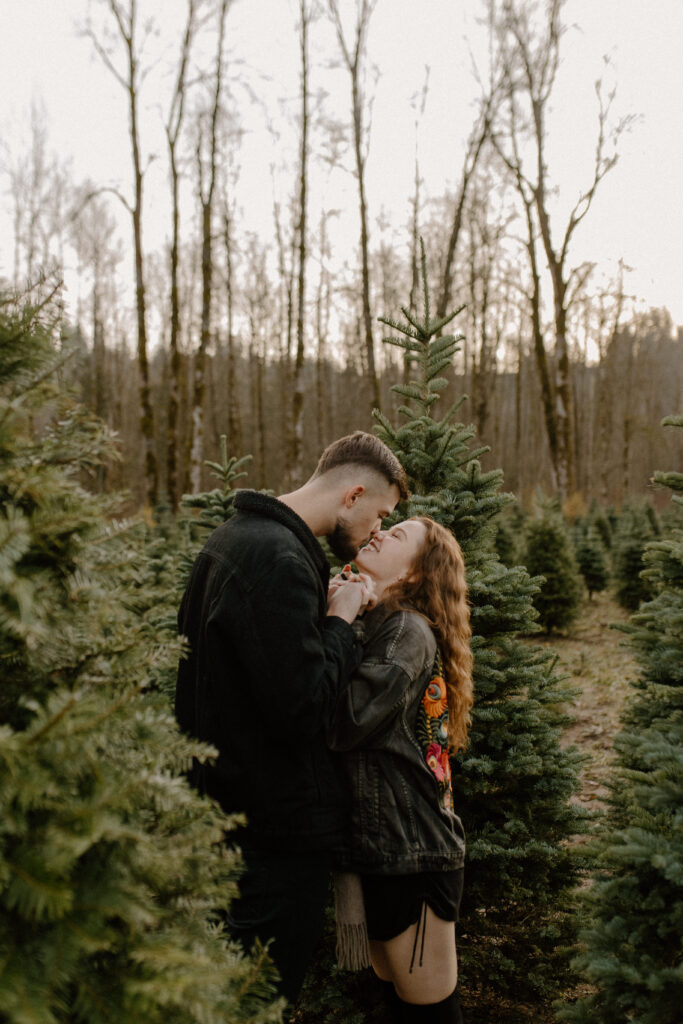 couples posing for holiday tree farm photoshoot