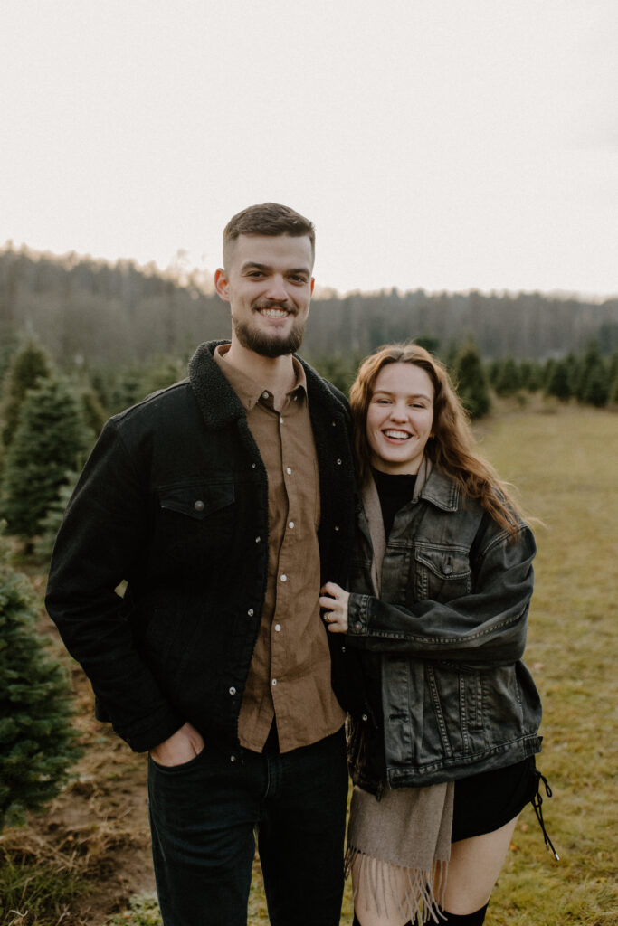 couples posing for holiday tree farm photoshoot