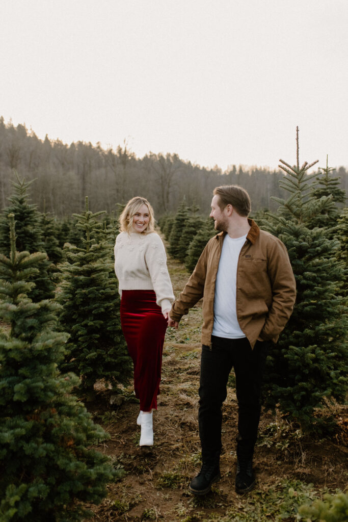 couples posing for holiday tree farm photoshoot