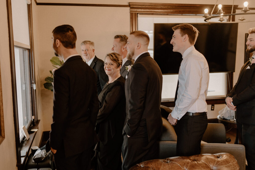 wedding party peeking on the bride and groom 