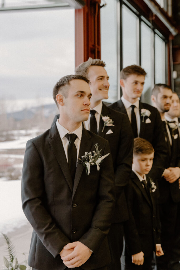 groom watching bride walk down the aisle 