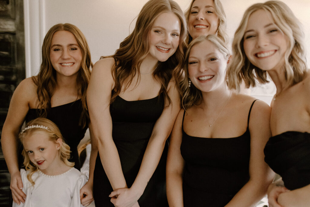 bridesmaids peaking on the bride in her dress