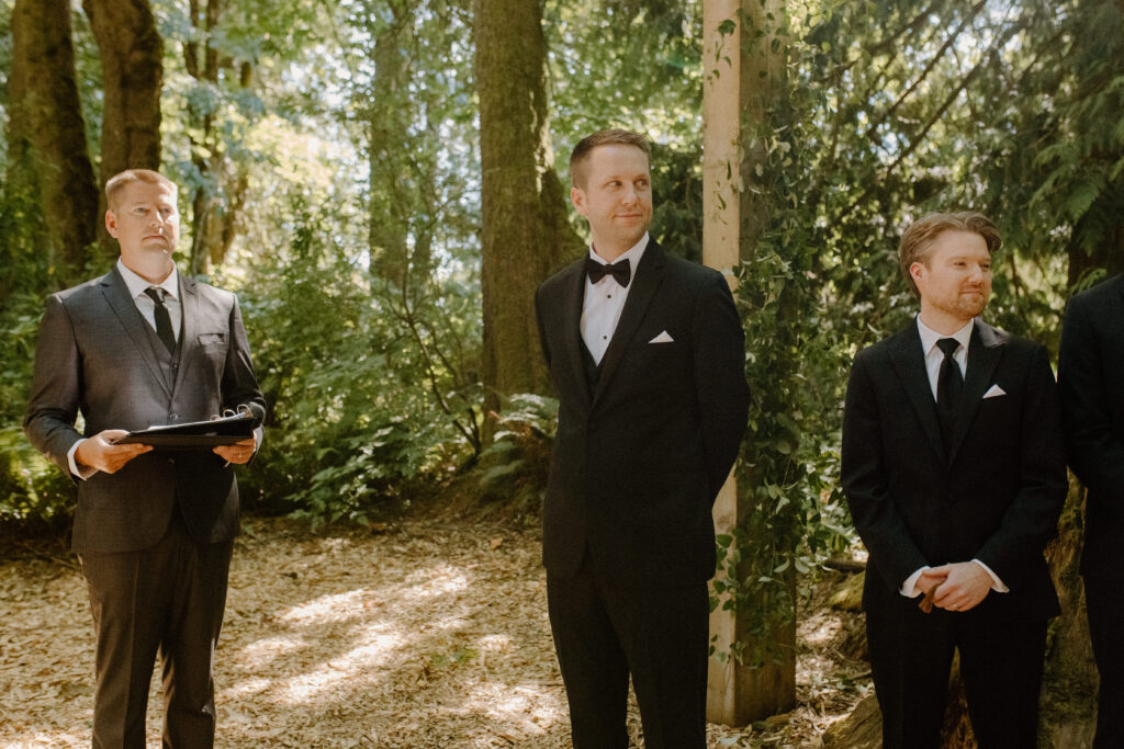groom watching bride walk down the aisle 